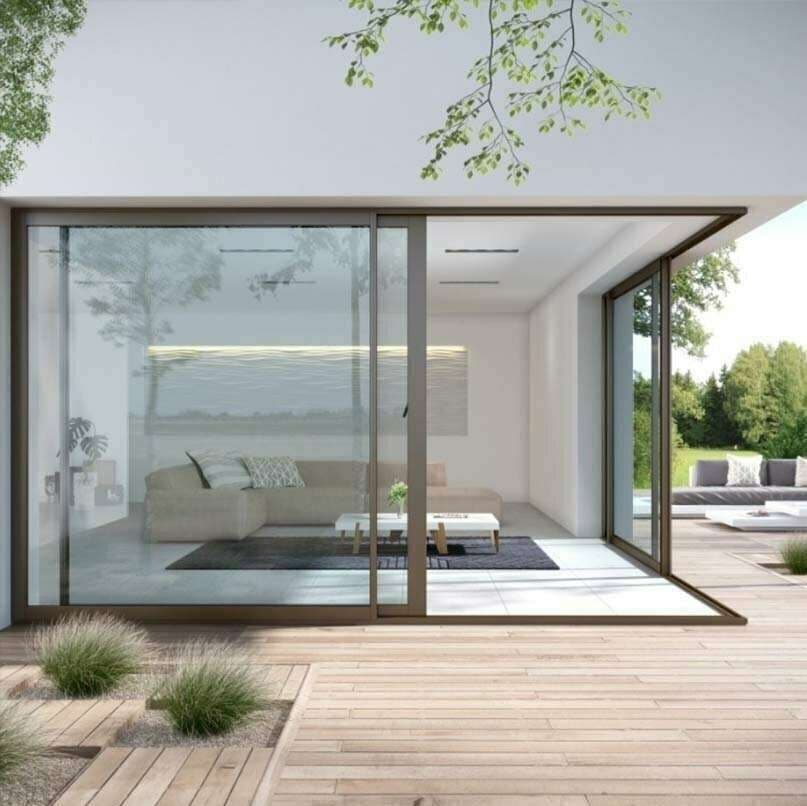 Grande baie coulissante aluminium bronze ouvrant un salon sur une terrasse en bois