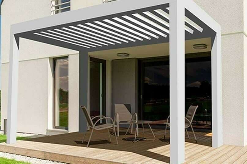 Pergola bioclimatique blanche à lames orientables au-dessus d'une terrasse en bois