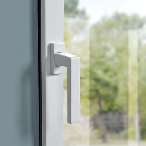 Gros plan sur la poignée blanche d'une fenêtre aluminium